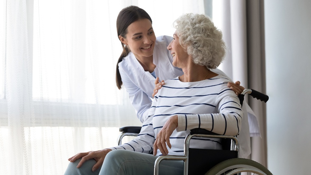A care coordinator visits with an elderly woman at her home, reviewing her care plan