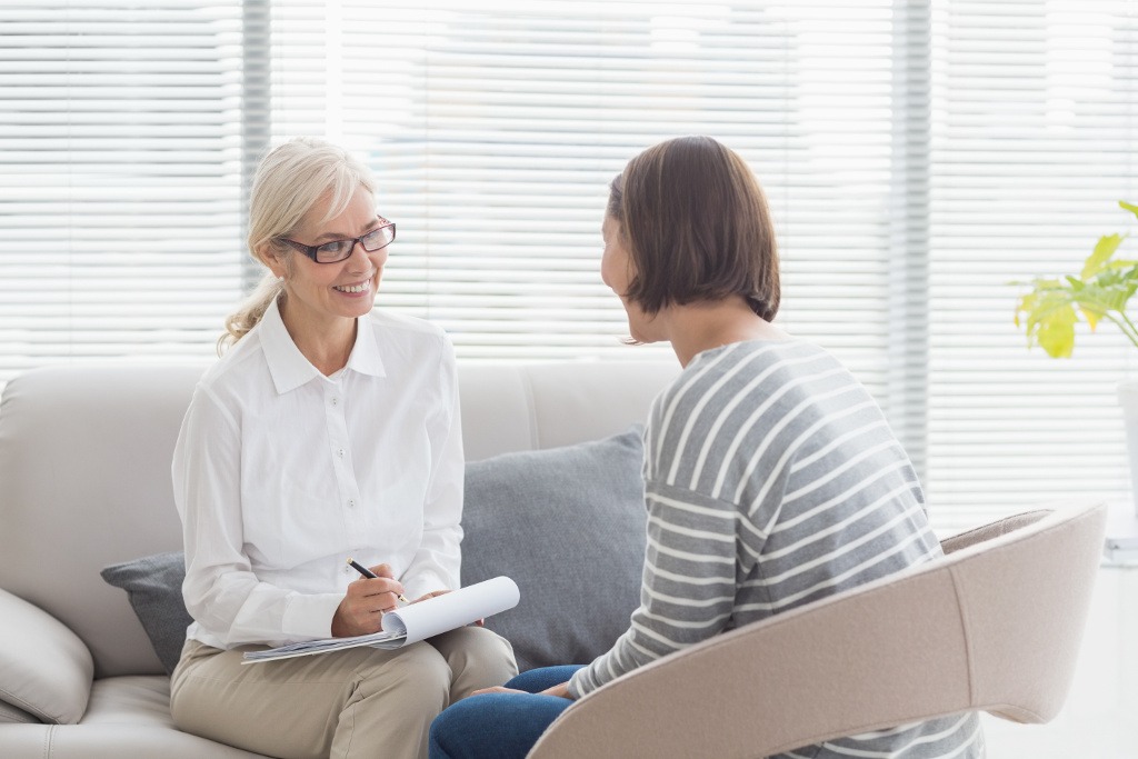 A care coordinator reviews housing paperwork with a client at a desk