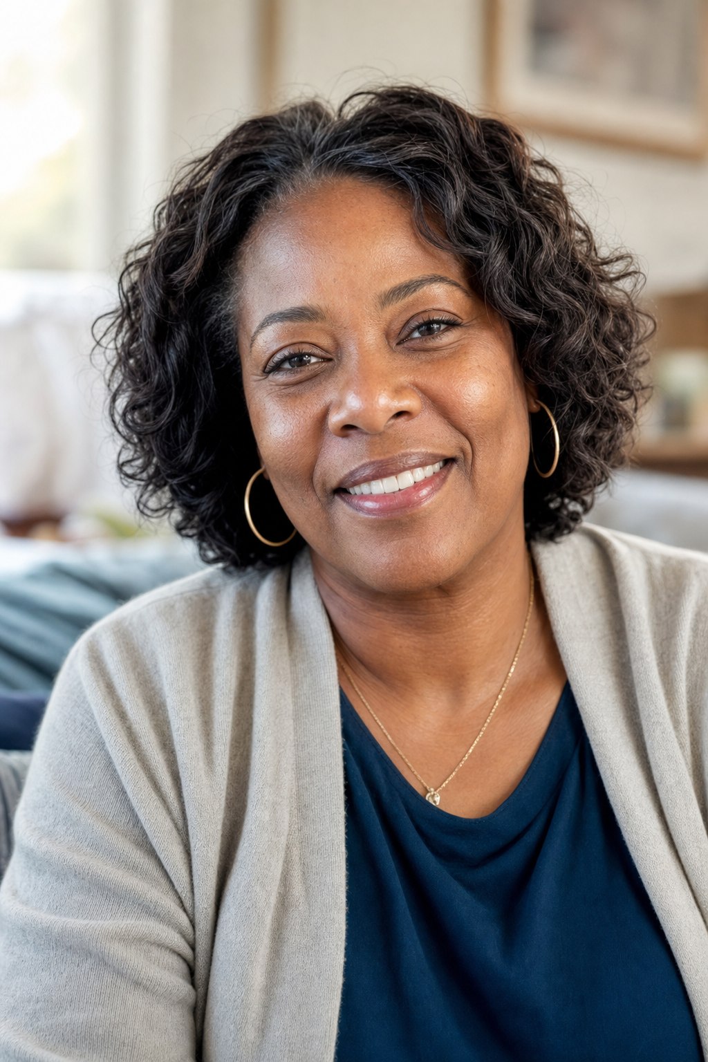 A smiling older woman sits comfortably at home, representing the dignity and independence BLH supports.